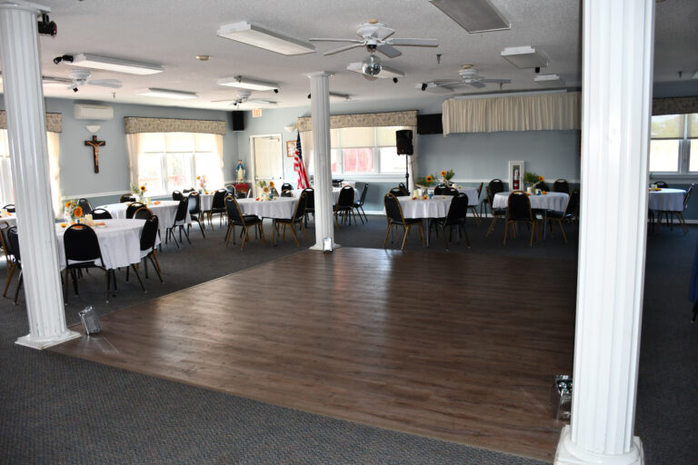 Large 10-person tables arranged around hardwood dance floor